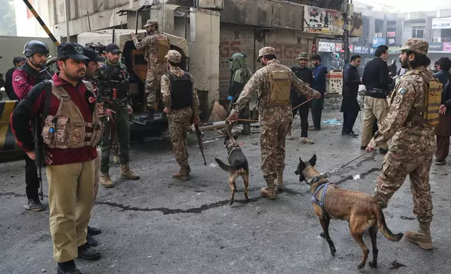 Army soldiers arrive with sniffer dogs after suicide bombers attacked the headquarters of the Federal Constabulary (FC), in Peshawar, Pakistan, Monday, Nov. 24, 2025. (AP Photo/Muhammad Zubair)