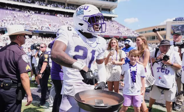 FILE - TCU safety Bud Clark (21) celebrates with the "iron skillet" after the team's win over SMU in an NCAA college football game, Saturday, Sept. 20, 2025, in Fort Worth, Texas. (AP Photo/Tony Gutierrez, File)