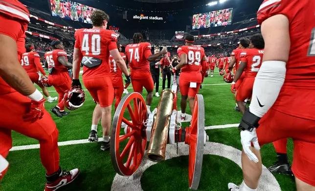 FILE - UNLV pulls the Fremont Cannon trophy, awarded to the winner of the annual Battle of Nevada game, on the field after defeating Nevada in an NCAA college football game Saturday, Nov. 30, 2024, in Las Vegas. (AP Photo/David Becker, File)