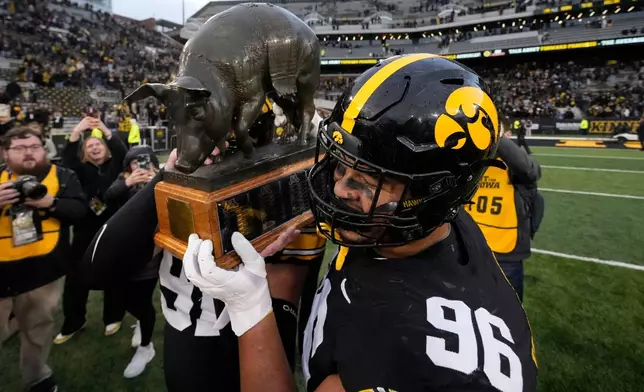 FILE - Iowa defensive lineman Bryce Hawthorne (96) celebrates with the Floyd of Rosedale trophy after an NCAA college football game against Minnesota, Saturday, Oct. 25, 2025, in Iowa City, Iowa. (AP Photo/Charlie Neibergall, File)