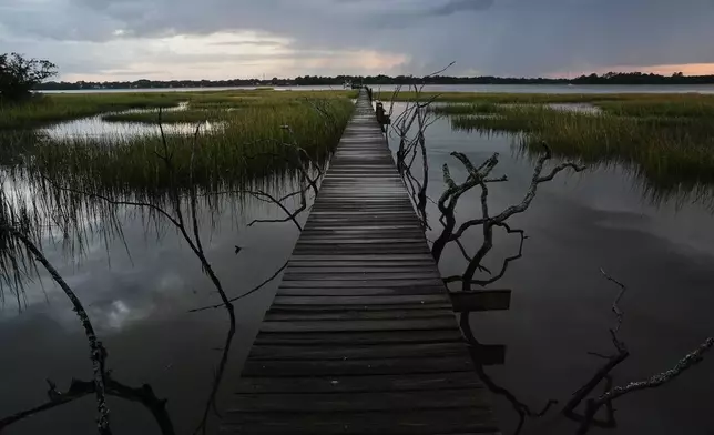 A storm moves through a salt marsh at sunset Monday, Oct. 6, 2025, in Charleston, S.C. (AP Photo/Joshua A. Bickel)