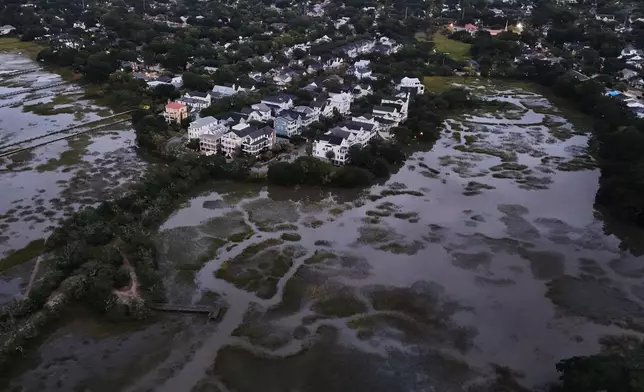 Houses sit next to a salt marsh at high tide, Monday, Oct. 6, 2025, in Charleston, S.C. (AP Photo/Joshua A. Bickel)