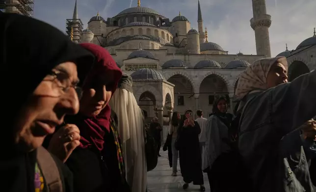 Locals and tourists visit the Ottoman-era Sultan Ahmed or Blue Mosque, in Istanbul, Turkey, Friday, Nov. 21, 2025, ahead of the visit of Pope Leo XIV to Turkey. (AP Photo/Francisco Seco)