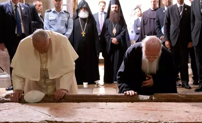 FILE - Pope Francis and Constantinople Patriarch Bartholomew kneel to kiss the Stone of Unction in the Church of the Holy Sepulchre, in Jerusalem, Israel, Sunday, May 25, 2014. (AP Photo/Andrew Medichini, Pool, File)