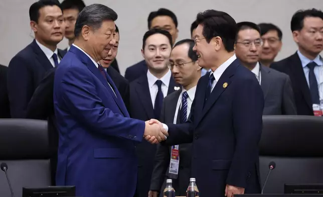 South Korean President Lee Jae Myung, right, shakes hands with Chinese President Xi Jinping at the Asia-Pacific Economic Cooperation (APEC) Economic Leaders' Meeting in Gyeongju, South Korea, Saturday, Nov. 1, 2025. (Yonhap via AP)