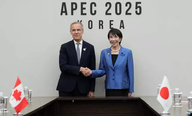 Canada's Prime Minister Mark Carney, left, meets with Japanese Prime Minister Sanae Takaichi at the APEC summit in Gyeongju, South Korea, Saturday, Nov. 1, 2025. (Adrian Wyld/The Canadian Press via AP)