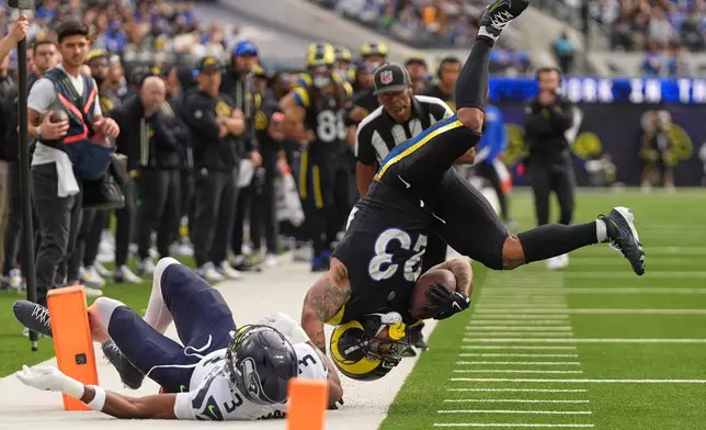 Los Angeles Rams running back Kyren Williams, right, is hauled out of bounds by Seattle Seahawks safety Nick Emmanwori during the first half of an NFL football game Sunday, Nov. 16, 2025, in Inglewood, Calif. (AP Photo/Gregory Bull)