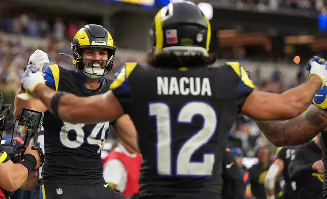 Los Angeles Rams tight end Colby Parkinson, left, celebrates his touchdown with wide receiver Puka Nacua during the second half of an NFL football game against the Seattle Seahawks, Sunday, Nov. 16, 2025, in Inglewood, Calif. (AP Photo/Gregory Bull)