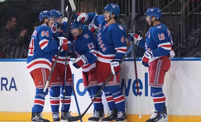 New York Rangers' Alexis Lafrenière (13) celebrates with teammates after scoring a goal during the second period of an NHL hockey game against the Nashville Predators Monday, Nov. 10, 2025, in New York. (AP Photo/Frank Franklin II)