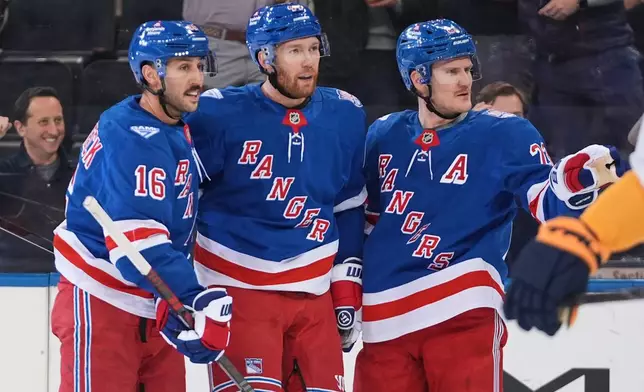 New York Rangers' Vladislav Gavrikov, center, celebrates with Vincent Trocheck, left, and Adam Fox after scorign a goal during the first period of an NHL hockey game against the Nashville Predators Monday, Nov. 10, 2025, in New York. (AP Photo/Frank Franklin II)