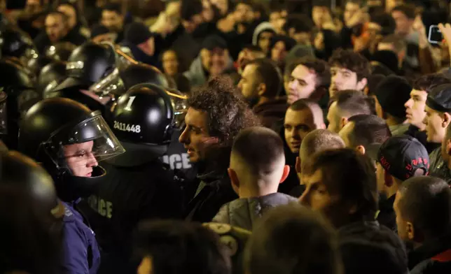 Protesters scuffle with police as thousands took to the streets of Bulgaria's capital, Sofia, to denounce steep tax hikes in next year's draft budget before being finally voted on in parliament, Wednesday, Nov 26, 2025. (AP Photo/Valentina Petrova)