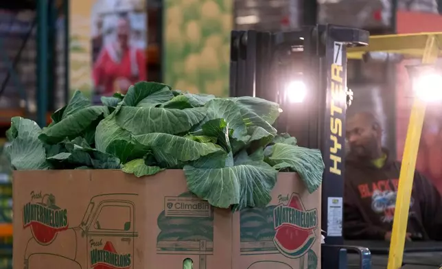 An employee uses a forklift to move boxes of produce at a warehouse of the Capital Area Food Bank, Thursday, Nov. 6, 2025, in Washington. (AP Photo/Mark Schiefelbein)