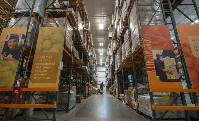 An employee moves pallets of food at a warehouse of the Capital Area Food Bank, Thursday, Nov. 6, 2025, in Washington. (AP Photo/Mark Schiefelbein)