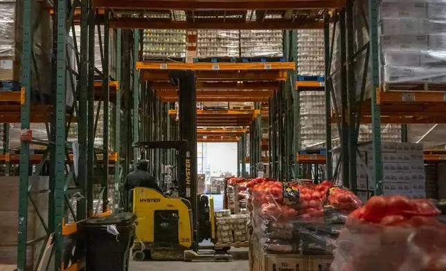 An employee drives a forklift at a warehouse of the Capital Area Food Bank, Thursday, Nov. 6, 2025, in Washington. (AP Photo/Mark Schiefelbein)