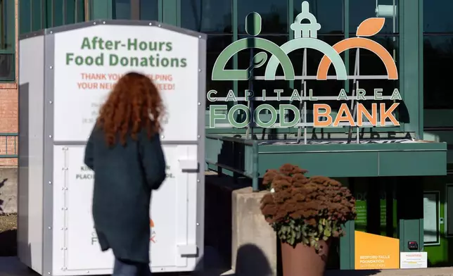 A person walks toward the entrance of the Capital Area Food Bank, Thursday, Nov. 6, 2025, in Washington. (AP Photo/Mark Schiefelbein)