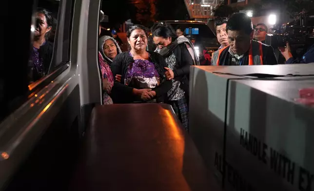 Vilma Pérez cries next to the coffin of her daughter Maria Florinda Ríos Perez, who was killed in Indiana, at La Aurora International Airport in Guatemala City, Sunday, Nov. 23, 2025. (AP Photo/Moises Castillo)