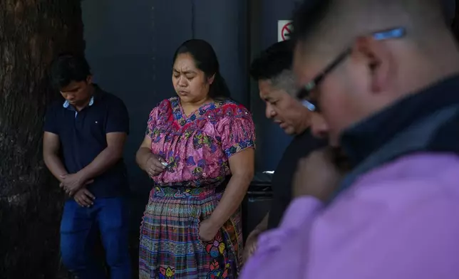 Relatives of migrant Maria Florinda Ríos Perez, who was killed in Indiana, pray as they wait for her body outside La Aurora International Airport in Guatemala City, Sunday, Nov. 23, 2025. (AP Photo/Moises Castillo)