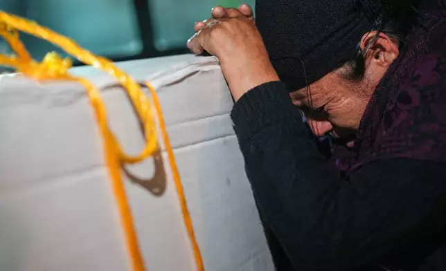 Vilma Pérez cries over the coffin of her daughter Maria Florinda Ríos Perez who was killed in Indiana, at La Aurora International Airport in Guatemala City, Sunday, Nov. 23, 2025. (AP Photo/Moises Castillo)