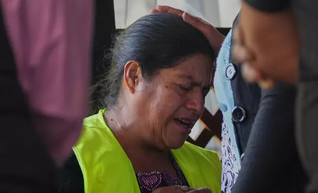 Vilma Pérez, the mother of migrant Maria Florinda Ríos Perez who was killed in Indiana, prays while waiting for her body, outside La Aurora International Airport in Guatemala City, Sunday, Nov. 23, 2025. (AP Photo/Moises Castillo)
