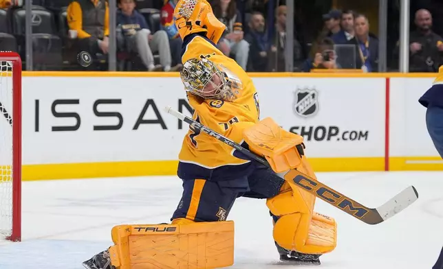 Nashville Predators goaltender Juuse Saros (74) deflects a shot on goal during the first period of an NHL hockey game against the Calgary Flames, Saturday, Nov. 1, 2025, in Nashville, Tenn. (AP Photo/Camden Hall)