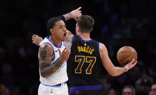 Utah Jazz guard Keyonte George (3) reacts to a foul call on him while defending Los Angeles Lakers guard Luka Doncic (77) during the first half of an NBA basketball game Tuesday, Nov. 18, 2025, in Los Angeles. (AP Photo/Jae C. Hong)