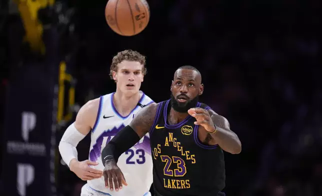 Los Angeles Lakers forward LeBron James (23) looks to grab a pass under pressure by Utah Jazz forward Lauri Markkanen (23) during the first half of an NBA basketball game Tuesday, Nov. 18, 2025, in Los Angeles. (AP Photo/Jae C. Hong)
