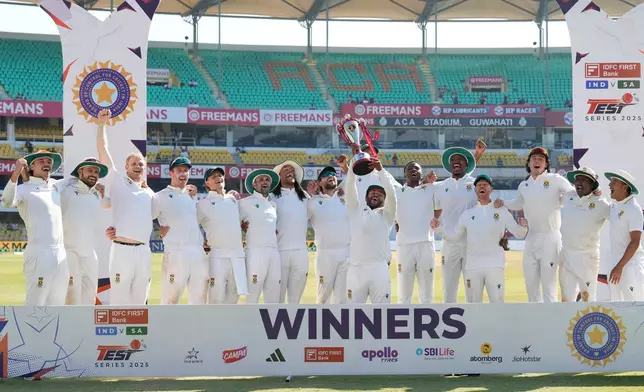 South Africa's cricket team celebrates with the trophy after winning the test series against India in Guwahati, India, Saturday, Nov. 22, 2025. (AP Photo/Anupam Nath)