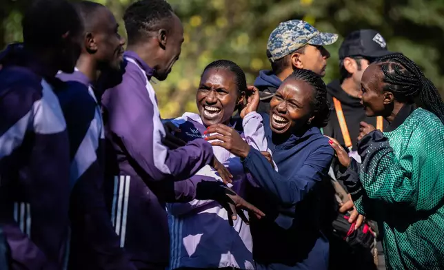 The six winners of the men's and women's elite divisions, celebrate together before the medal ceremony after winning the New York City Marathon, Sunday, Nov. 2, 2025, in New York. (AP Photo/Angelina Katsanis)