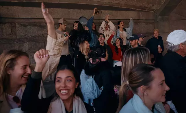 People cheer as runners pass by during the New York City Marathon in New York, Sunday, Nov. 2, 2025. (AP Photo/Andres Kudacki)
