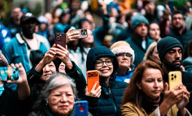 People view the Rockefeller Center Christmas tree while it's lifted by a crane into place at Rockefeller Plaza, Saturday, Nov. 8, 2025, in New York. (AP Photo/Eduardo Munoz Alvarez)