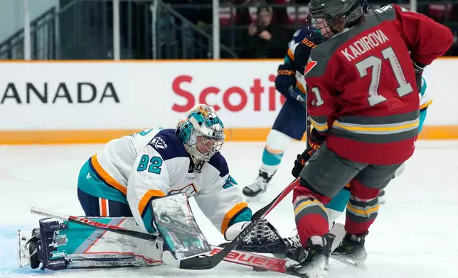 New York Sirens goaltender Kayle Osborne (82) makes a save in front of Ottawa Charge's Fanuza Kadirova (71) during first period PWHL hockey action in Ottawa, on Saturday, Nov. 22, 2025. (Justin Tang/The Canadian Press via AP)