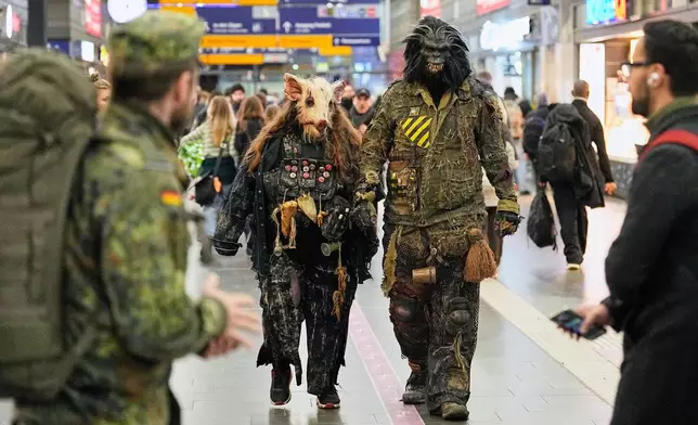 People dressed in scary costumes arrive at a train station to take part in a Halloween Zombie protest walk at the city center of Essen, Germany, Friday, Oct. 31, 2025. (AP Photo/Martin Meissner)