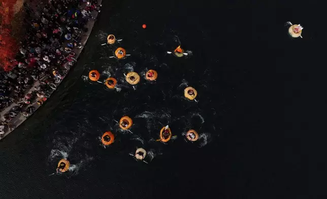People race in giant pumpkins during the West Coast Giant Pumpkin Regatta on Sunday, Oct. 19, 2025, in Tualatin, Ore. (AP Photo/Jenny Kane)