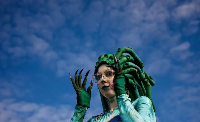 A girl adjusts her outfit at the West Side Hallo Fest, the country's largest Halloween festival in Bucharest, Romania, Saturday, Oct. 25, 2025. (AP Photo/Andreea Alexandru)