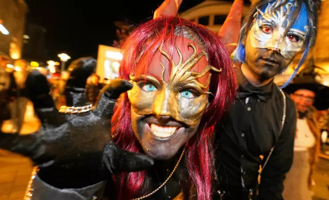 People dressed up in scary costumes take part in a Halloween Zombie protest walk at the city center of Essen, Germany, Friday, Oct. 31, 2025. (AP Photo/Martin Meissner)