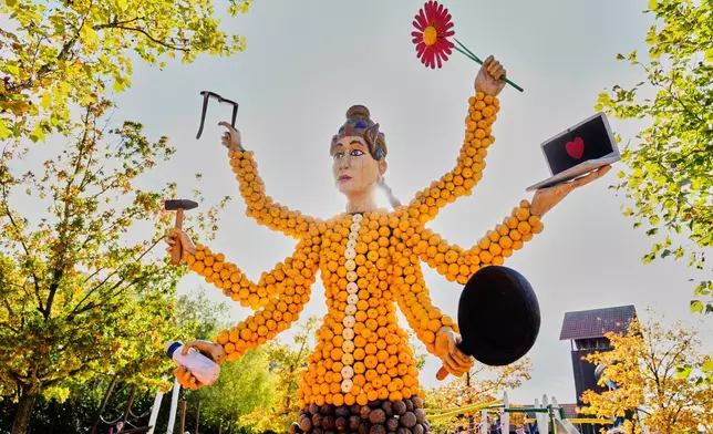 A pumpkin sculpture depicting a goddess with six arms, is displayed at Klaistow farm’s annual pumpkin festival, which this year celebrates “powerful women,” in Beelitz near Berlin, Germany, Tuesday, Oct. 21, 2025. (AP Photo/Markus Schreiber)