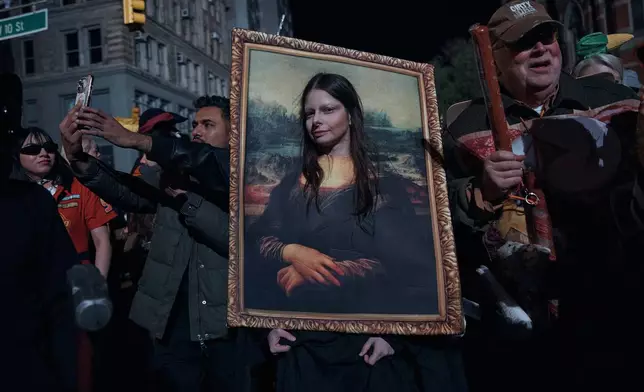 A reveler pauses for a photograph during the Village Halloween Parade on Friday, Oct. 31, 2025, in New York. (AP Photo/Andres Kudacki)
