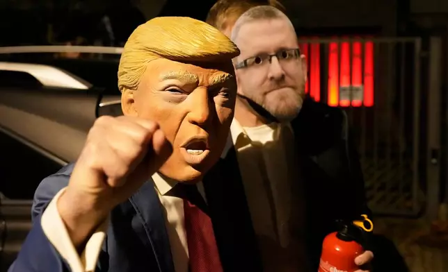 A person wearing a Donald Trump costume for a Halloween party gestures in Warsaw, Poland, Friday, Oct. 31, 2025. (AP Photo/Czarek Sokolowski)