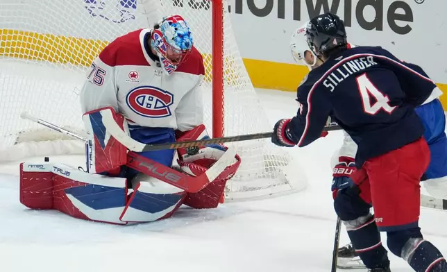 Montreal Canadiens goaltender Jakub Dobes (75) stops a shot by Columbus Blue Jackets center Cole Sillinger (4) in the first period of an NHL hockey game in Columbus, Monday, Nov. 17, 2025. (AP Photo/Sue Ogrocki)