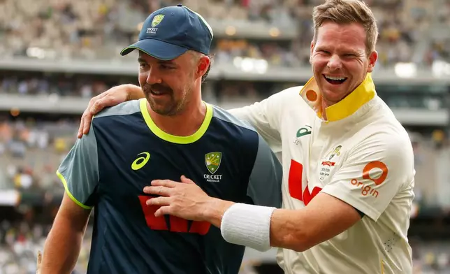 Australia's captain Steve Smith, right, and Travis Head celebrate after winning their first Ashes cricket test match against England in Perth, Saturday, Nov. 22, 2025.(AP Photo/Gary Day)