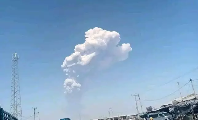 In this photo released by the Afar Government Communication Bureau, people watch ash billow from the first time eruption of the Hayli Gubbi Volcano in Ethiopia's Afar region Sunday, Nov. 23, 2025. (Afar Government Communication Bureau via AP)
