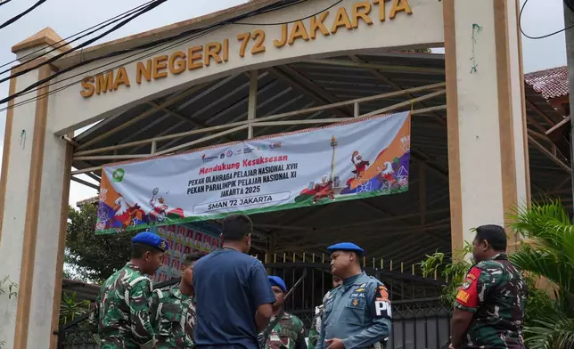 Military personnel stand guard at the gate of a school after explosions in Jakarta, Indonesia, Saturday, Nov. 8, 2025. (AP Photo/Achmad Ibrahim)