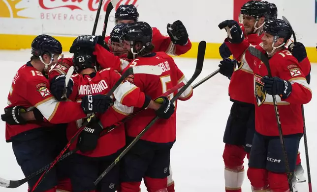 Florida Panthers players celebrate left wing Brad Marchand (63) after he reached his 1,000 career points during the third period of an NHL hockey game against the Washington Capitals, Thursday, Nov. 13, 2025, in Sunrise, Fla. (AP Photo/Marta Lavandier)