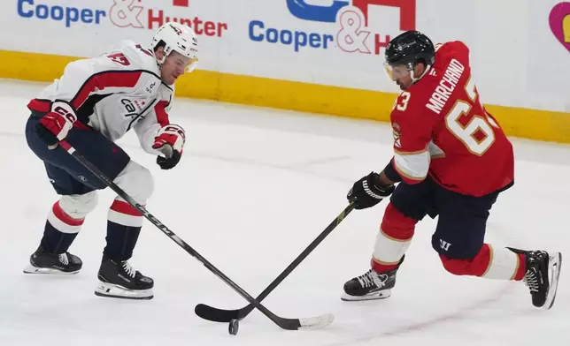 Washington Capitals defenseman Declan Chisholm (47) and Florida Panthers left wing Brad Marchand (63) got after the puck during the first period of an NHL hockey game, Thursday, Nov. 13, 2025, in Sunrise, Fla. (AP Photo/Marta Lavandier)
