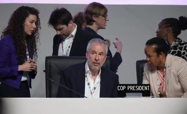 André Corrêa do Lago, COP30 president, center, arrives for a plenary session at the COP30 U.N. Climate Summit, Saturday, Nov. 22, 2025, in Belem, Brazil. (AP Photo/Fernando Llano)
