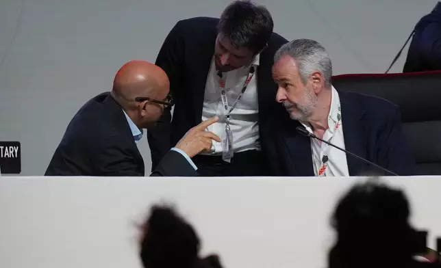 Simon Stiell, United Nations climate chief, left, speaks with André Corrêa do Lago, COP30 president, right, before a plenary session at the COP30 U.N. Climate Summit, Saturday, Nov. 22, 2025, in Belem, Brazil. (AP Photo/Fernando Llano)