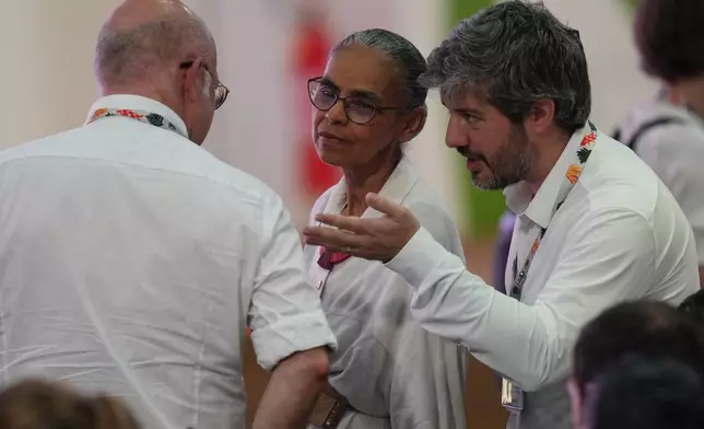 Marina Silva, Brazil environment minister, center, speaks with delegates as she waits for the start of a plenary session at the COP30 U.N. Climate Summit, Saturday, Nov. 22, 2025, in Belem, Brazil. (AP Photo/Andre Penner)