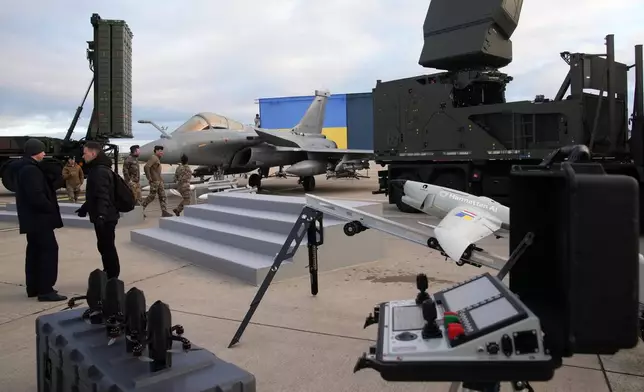 A Rafale jet fighter, drones and ammunitions are seen before the arrival of Ukrainian President Volodymyr Zelenskyy Monday, Nov. 17, 2025 at the Villacoublay air base near Paris. (AP Photo/Christophe Ena, Pool)