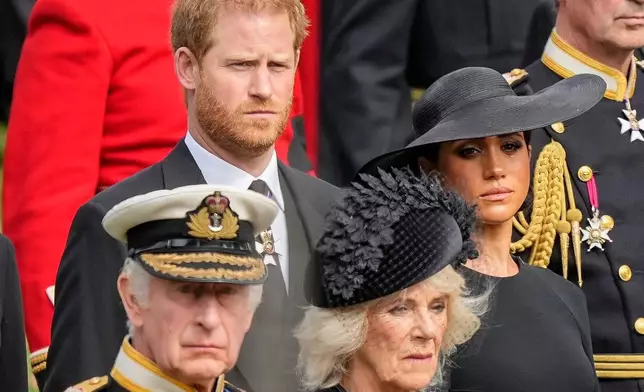 FILE - Britain's King Charles III, from bottom left, Camilla, the Queen Consort, Prince Harry and Meghan, Duchess of Sussex watch as the coffin of Queen Elizabeth II is placed into the hearse following the state funeral service in Westminster Abbey in central London Monday Sept. 19, 2022. (AP Photo/Martin Meissner, Pool, File)