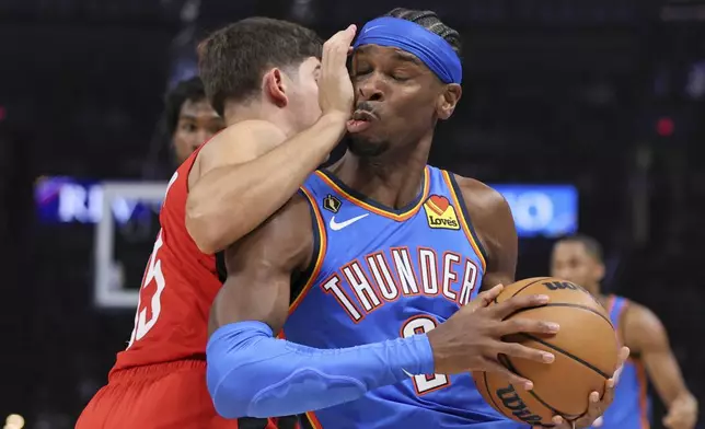 Oklahoma City Thunder guard Shai Gilgeous-Alexander, right, collides with Houston Rockets guard Reed Sheppard during the first half of an NBA basketball game Tuesday, Oct. 21, 2025, in Oklahoma City. (AP Photo/Nate Billings)